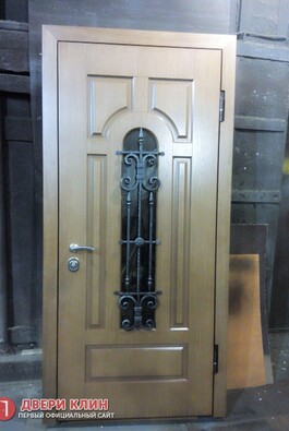 Элитная входная дверь в коттедж с элементами ковки и стеклом